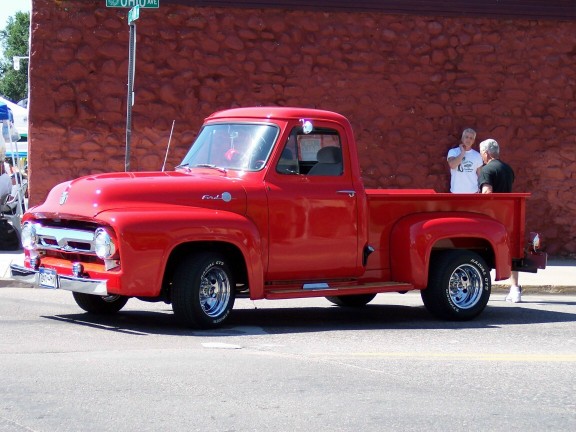 Red 1956 Ford F-100 pickup truck parked on street