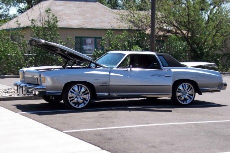 1972 Ford Ranchero - A silver 1973 Chevrolet El Camino is parked with its hood open, revealing the engine bay.