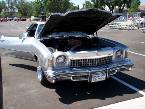 1972 Ford Ranchero - A silver coupe is parked with its hood and driver's door open, revealing the engine compartment.