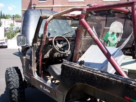 1972 Ford Ranchero - Muddy off-road Jeep interior a roll cage and a pirate skull flag on the back.