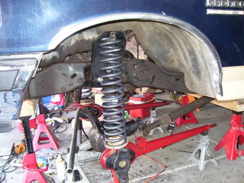 1991 Ford Bronco - The suspension system of a 1991 Ford Bronco is shown from the side, elevated on jack stands for repair.