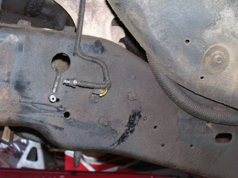 1991 Ford Bronco - Undercarriage view of a vehicle frame, showing brake lines and various mounting points.