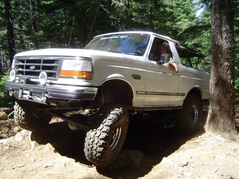 1989 Ford Bronco - This lifted 1992-1996 Ford Bronco navigates a challenging off-road course in a wooded area.