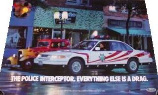 1995 Ford Crown Victoria - A police car and a vintage car are parked on a street at night, with a slogan at the bottom.
