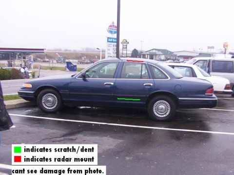 1995 Ford Crown Victoria - A blue 1995 Ford Crown Victoria is parked in a lot, with green markings indicating a scratch/dent and red markings indicating a radar mount.