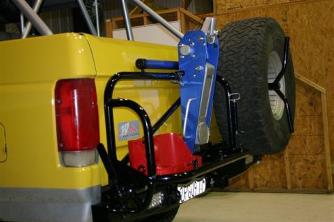 1984 Ford Bronco - Rear view of a yellow 1984 Ford Bronco, equipped with a spare tire carrier, jack, and auxiliary fuel can.