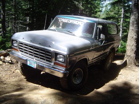 1989 Ford Bronco - This Ford Bronco is parked on a dirt path surrounded by trees. The license plate reads 'TBA079'.
