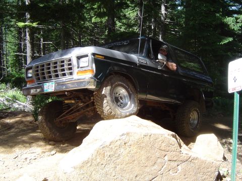 1989 Ford Bronco - Ford Bronco navigates a rocky obstacle during an off-road excursion.