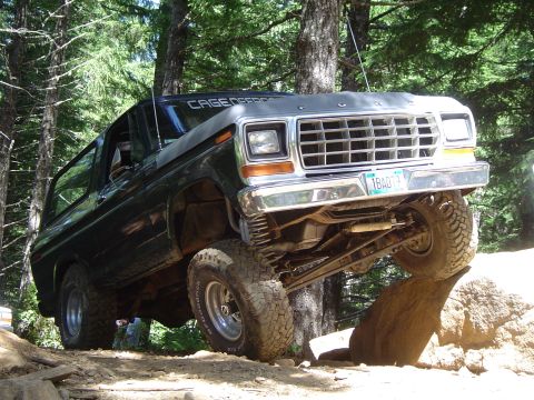 1989 Ford Bronco - This modified Ford Bronco is navigating a rocky obstacle on an off-road trail.