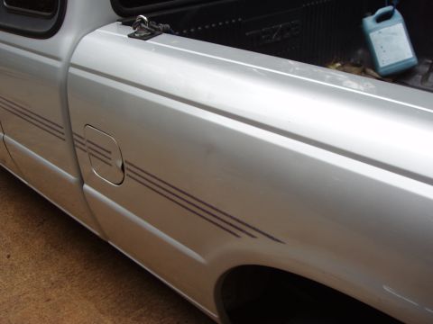 1994 Mazda B3000 - Side view of a silver 1994 Mazda B3000 pickup truck, with a blue jug in the bed.
