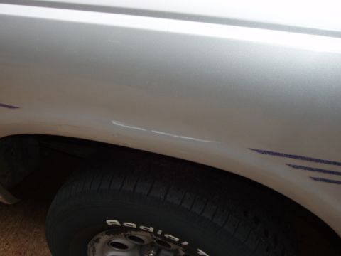 1994 Mazda B3000 - Close-up view of a silver truck fender and tire, pinstripe graphics and 'Radial' text on the tire sidewall.