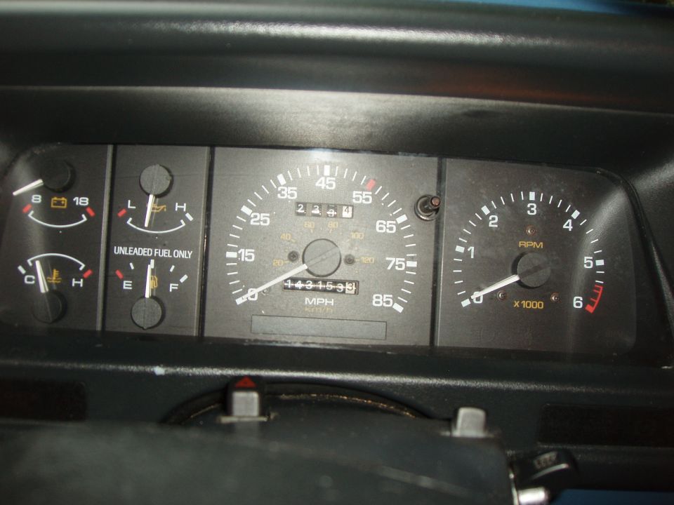 Dashboard gauges with speedometer, tachometer, fuel, and temperature gauges. Odometer reads 143153