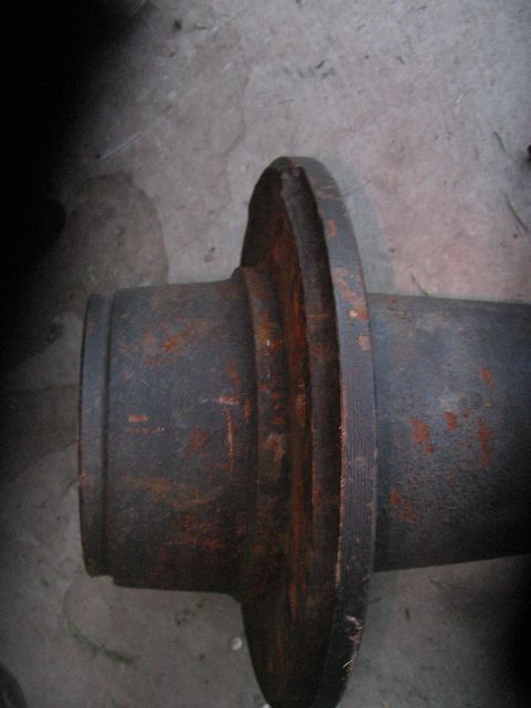 1994 Ford Bronco - Close-up of a rusted metal axle part with a prominent flange.
