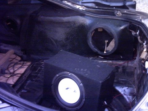 1995 Ford Probe - Subwoofer installed in the trunk of a car, with a speaker cutout visible.