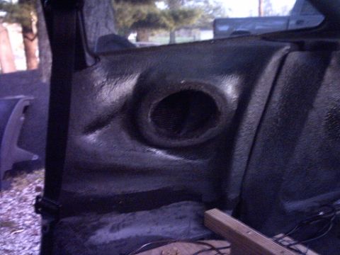 1995 Ford Probe - This photo shows a textured plastic speaker enclosure inside a vehicle's cabin.