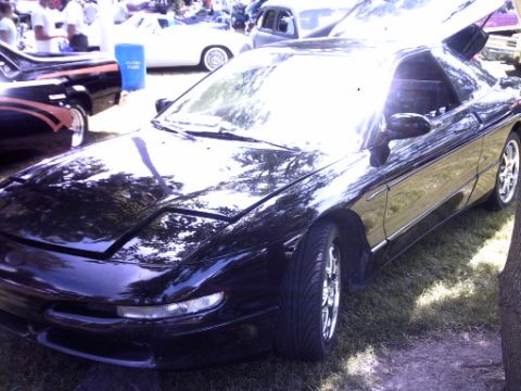 1995 Ford Probe - A black 1995 Ford Probe is parked outdoors with its hood and trunk open, showing off its interior and engine bay.