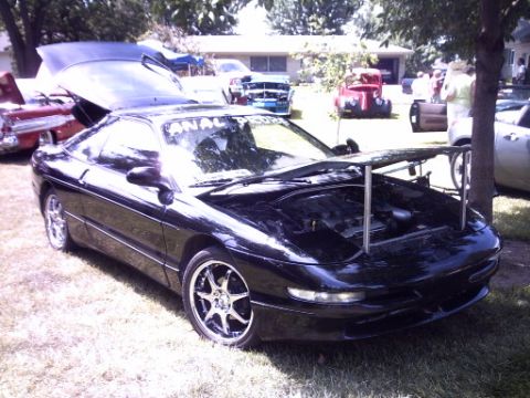1995 Ford Probe - Black 1995 Ford Probe on display with hoods open at a car show.