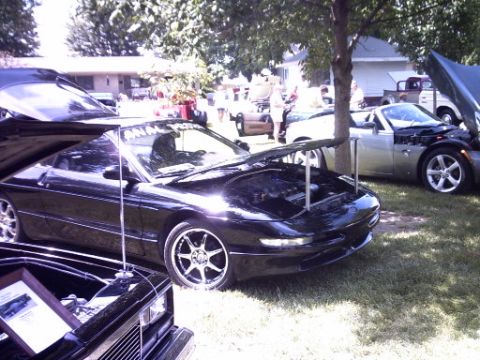 1995 Ford Probe - Several cars are displayed outdoors with their hoods open, suggesting a car show or exhibition.