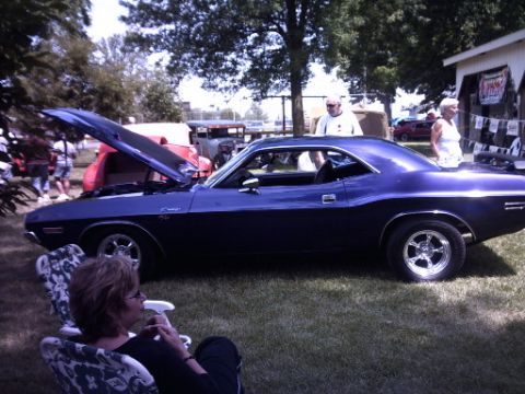 1995 Ford Probe - A classic muscle car is displayed outdoors with its hood up, while a woman relaxes nearby.