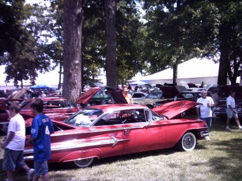 1995 Ford Probe - A red 1959 Chevrolet Impala is displayed with its hood open at an outdoor car show.