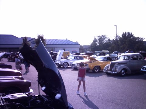 1995 Ford Probe - A car show features various classic vehicles, with a young girl observing the scene.