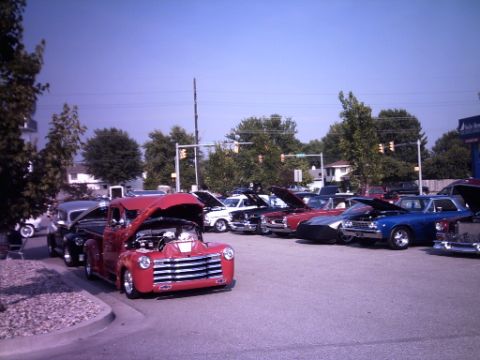1995 Ford Probe - Several classic vehicles are displayed with their hoods up at a car show event.