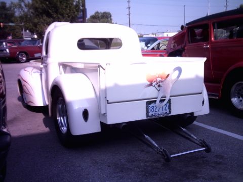 1995 Ford Probe - A custom white pickup truck is seen from the rear at a car show.