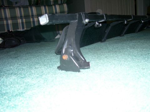 1991 Ford Bronco - A black roof rack mounting bracket with an orange reflector is shown indoors.