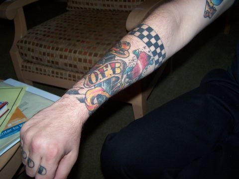 1995 Ford Probe - A tattooed arm displays various colorful designs, including a checkered band and a banner.