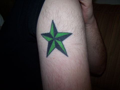 1995 Ford Probe - A close-up of a green and black star tattoo on a hairy arm, with a Supermotors logo visible.