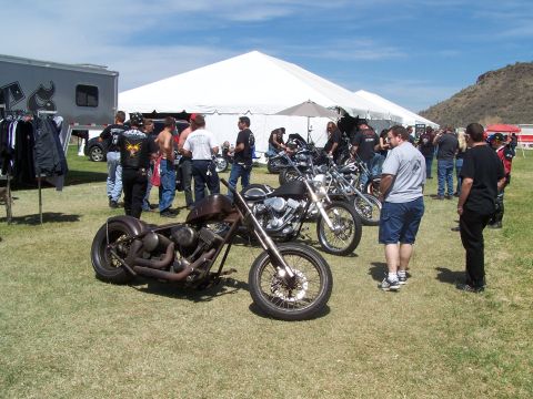1995 Ford Probe - Several custom motorcycles are displayed outdoors under a large white tent.