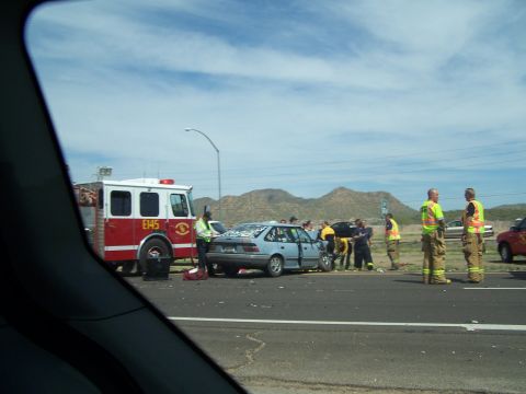 1995 Ford Probe - Emergency responders are present at a car accident scene involving a blue sedan and a fire truck.