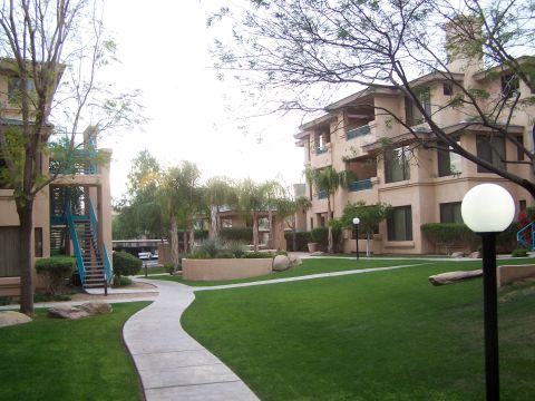 1995 Ford Probe - A view of an apartment complex courtyard with manicured lawns and palm trees.