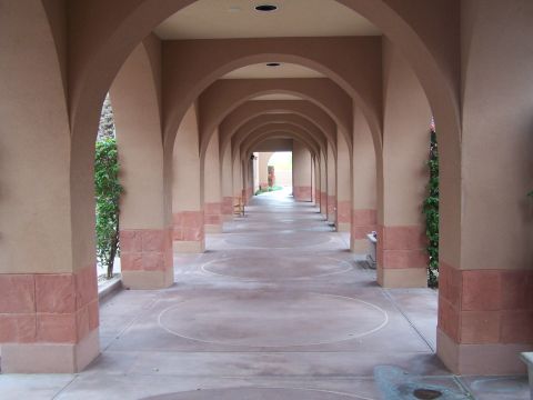 1995 Ford Probe - A long, covered walkway with repeating arches and columns, leading to an open doorway in the distance.