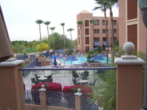 1995 Ford Probe - A resort scene with a pool, lounge chairs, and palm trees under a cloudy sky.
