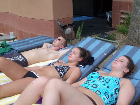 1995 Ford Probe - People relax on lounge chairs under the sun.
