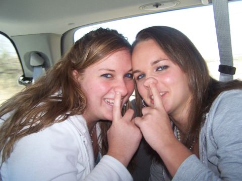 1995 Ford Probe - Two young women playfully pose inside a vehicle, each with a finger up their nose.