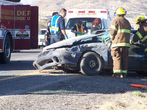 1995 Ford Probe - Emergency responders attend to a car accident involving a heavily damaged sedan and a fire truck.