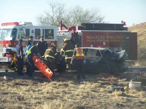 1995 Ford Probe - Emergency personnel attend to a vehicle involved in a crash, with a fire truck present at the scene.