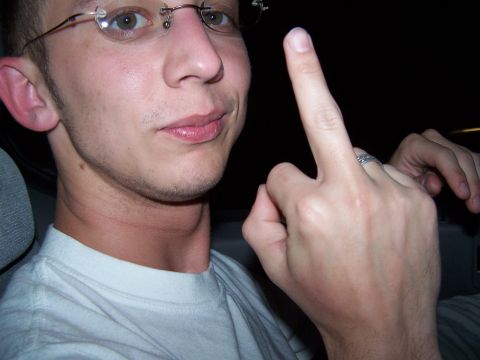 1995 Ford Probe - A man inside a vehicle gestures with his middle finger while looking at the camera.