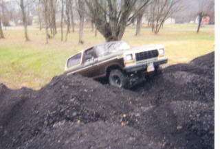 1979 Ford Bronco - A Ford Bronco navigates a steep incline of loose soil.