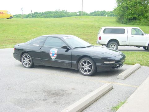 1995 Ford Probe - A black 1995 Ford Probe is parked in a lot next to a white pickup truck.