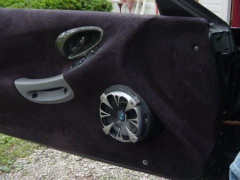 1995 Ford Probe - Close-up of a car's interior door panel, showing a custom speaker and window controls.