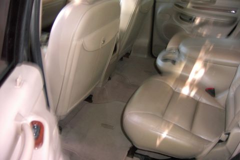 1996 Mercury Grand Marquis - The interior of a vehicle features tan leather seats and carpeting, with a view of the rear passenger area.