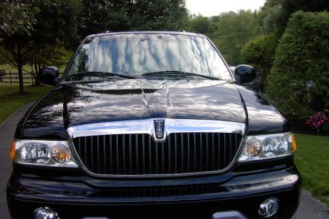 1996 Mercury Grand Marquis - Black Lincoln Navigator SUV parked outdoors, showing its front grille and headlights.