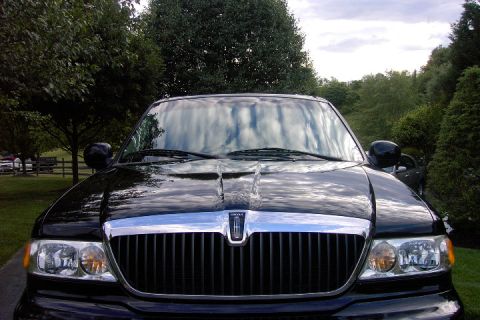 1996 Mercury Grand Marquis - The front of a black Lincoln Navigator is shown with a chrome grille and vertical bars.