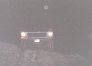 1979 Ford Bronco - A 1978 Ford Bronco is seen driving on a dirt road at night, with its headlights on.