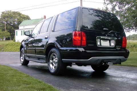 1996 Mercury Grand Marquis - Rear view of a black Lincoln Navigator with chrome wheels and a trailer hitch.
