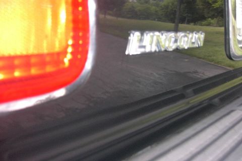 1996 Mercury Grand Marquis - Close-up of the Lincoln emblem on the rear of a dark-colored vehicle.