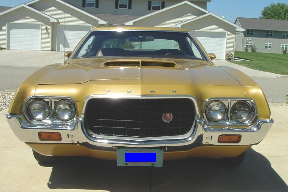 Front of gold 1972 Ford Gran Torino with cowl-induction hood scoop in a driveway